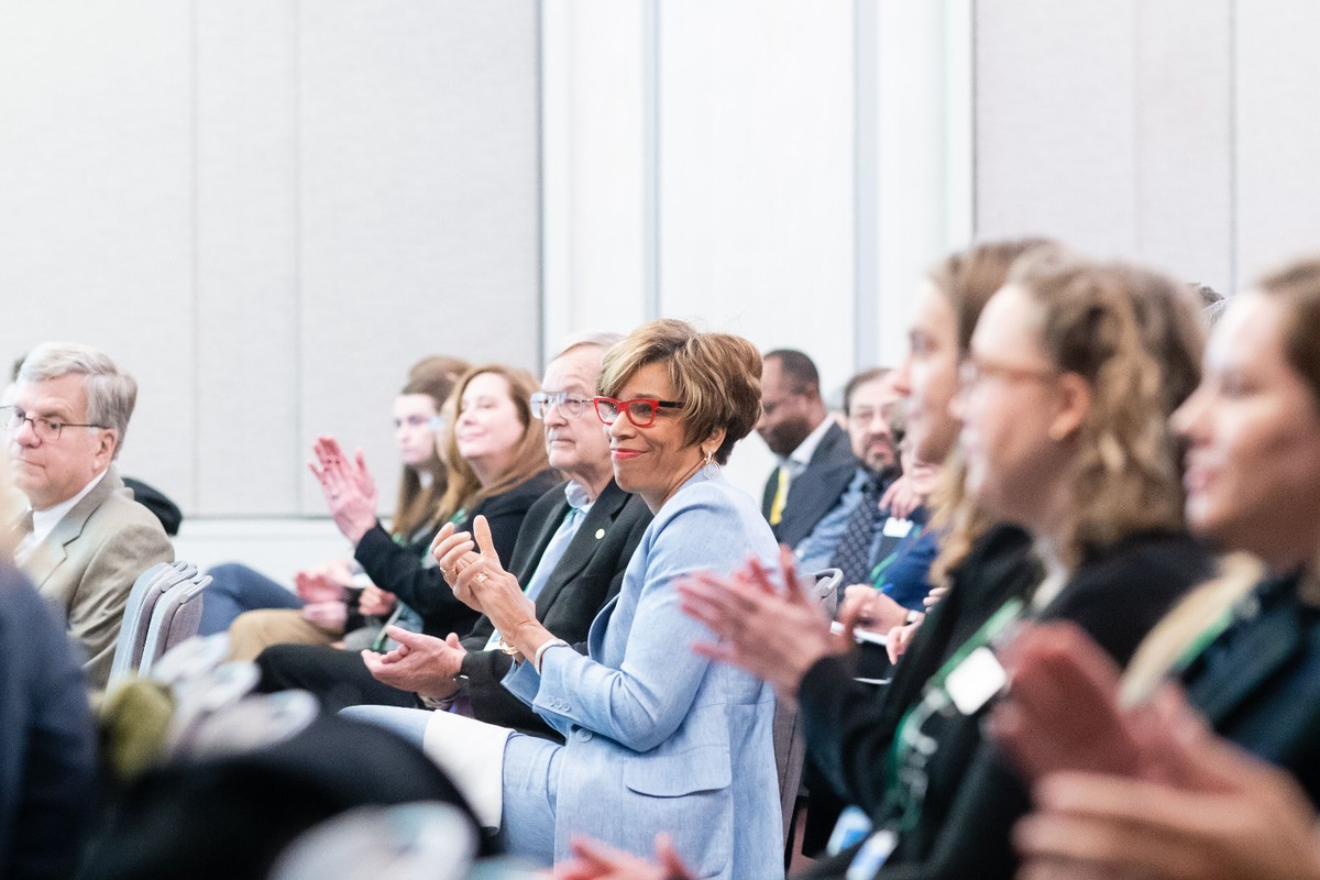 A crowd of attendees applauds at the award ceremony.